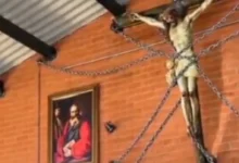 Sacerdote oficia misa con casco y una imagen de Jesús encadenada por seguridad